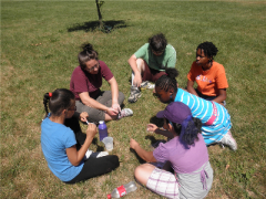Emily and children sitting in circle on grass